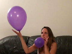 Good looking brunette blowing balloons