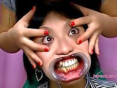 Cute Asian Girl gets her face stretched with toys